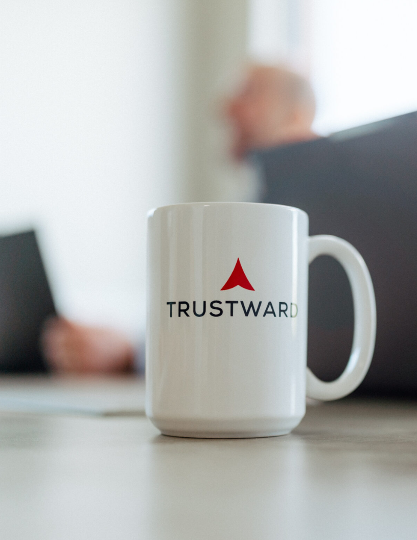 A Trustward Accounting branded mug sitting on a table.